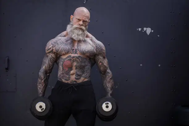 Photo of Tattooed Senior Man During Gym Workout