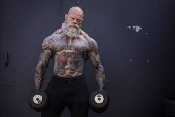 homem sênior tattooed durante o exercício da ginástica - macho - fotografias e filmes do acervo