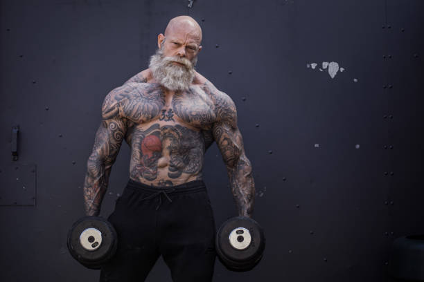 татуированный старший человек во время тренировки тренажерный зал - body building exercising one man only tattoo стоковые фото и изображения