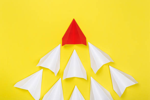 istock Red paper plane are different from others on yellow background. Think different. Business for innovative, solution concepts 1164854126