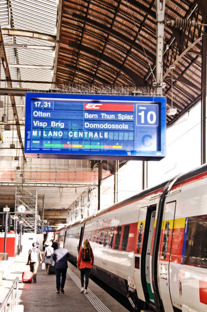 пассажиры и туристы, садясь в поезд ес в милане на федеральной железной дороге швейцарии (sbb cff ffs), владели компанией basel bff bahnhof (базельский во - swisscom стоковые фото и изображения