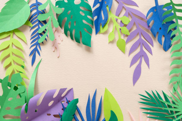 istock tropical leaves cut from paper on pink background. 1164855021