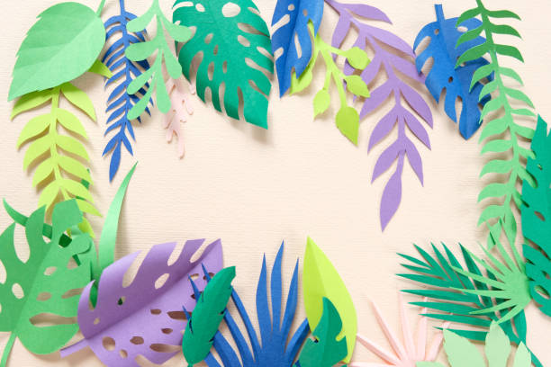 istock tropical leaves cut from paper on pink background. 1164855098