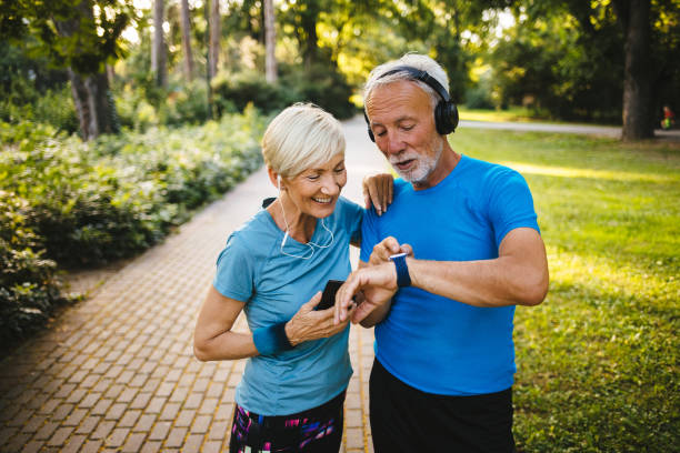 야외에서 운동하는 동안 스마트 시계를 사용하는 시니어 커플 - running cheerful outdoors senior couple 뉴스 사진 이미지
