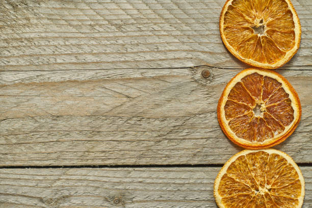 istock three dried orange slices on wooden background, top view, copy space 1164856083