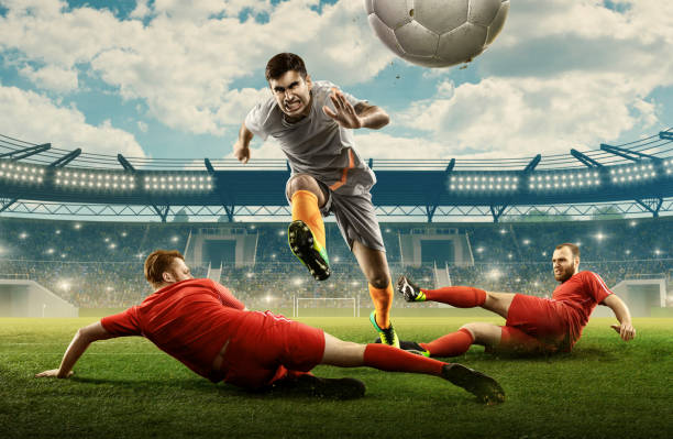 istock Three soccer players fight for a ball on a stadium 1164857229