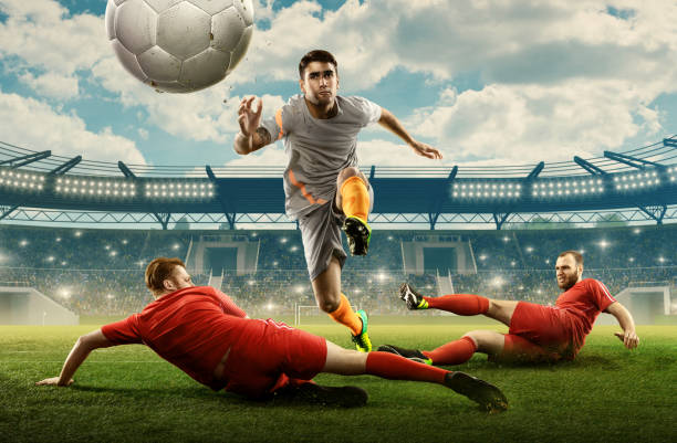 tre calciatori combattono per una palla in uno stadio - kick off soccer player soccer kicking foto e immagini stock