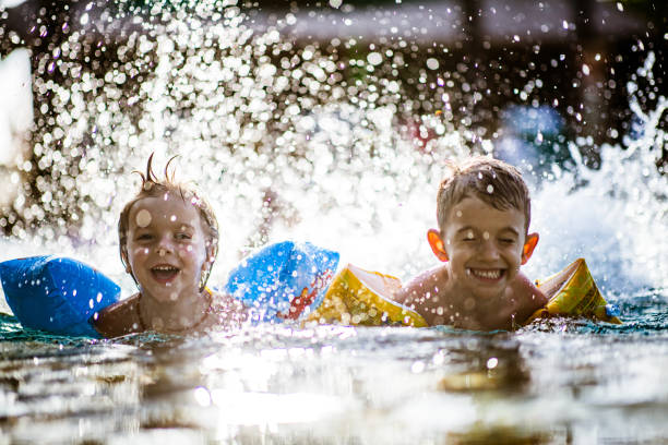 istock Happy little boys having fun while splashing water in summer day. 1164858690