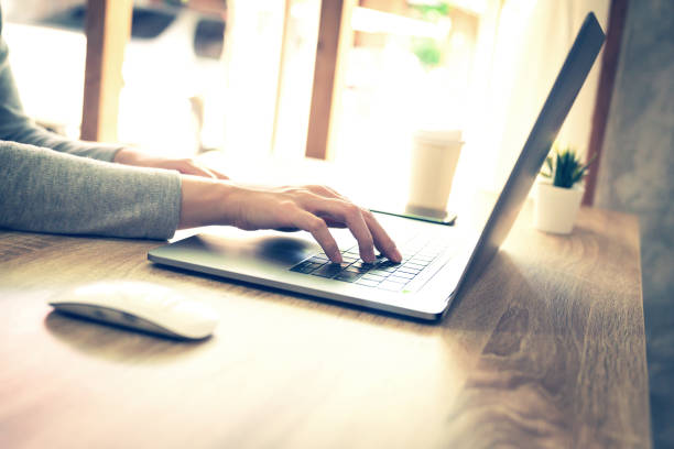 istock asian woman using laptop computer do online activity on wood table at home office. 1164862198