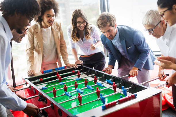 istock Employees playing table soccer indoor game in the office during break time 1164863119