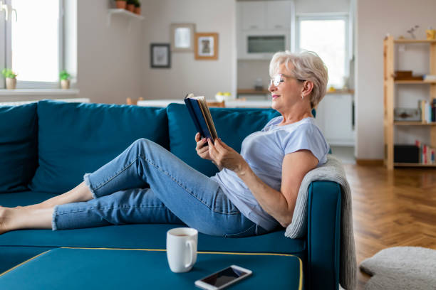 istock Senior Woman With Book at Home 1164866353
