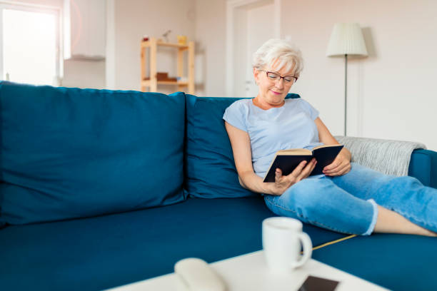 istock Senior Woman With Book at Home 1164866440