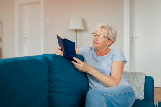 istock Senior Woman With Book at Home 1164866583
