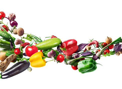 Concept of healthy nutrition. Flying vegetables at a white background. Diet.