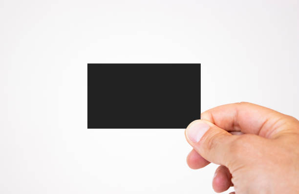 istock Man holding black business card mockup on isolated background 1164868954