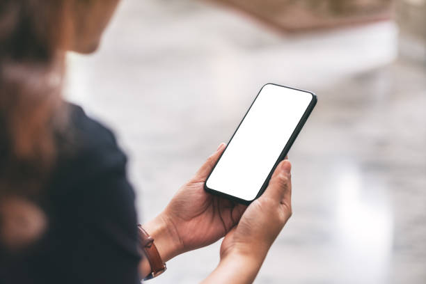 istock a woman holding black mobile phone with blank desktop screen 1164870885