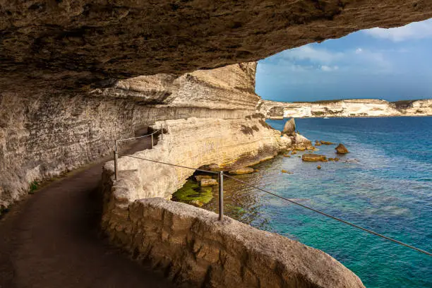 scenic path carved into the rock that runs along the sea in the town of bastia in corsica, france.