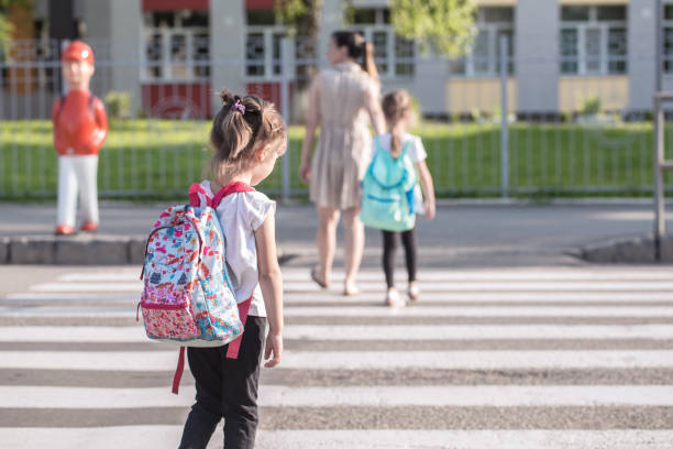 istock Back to school education concept with girl kids, elementary students, carrying backpacks going to class 1164873246