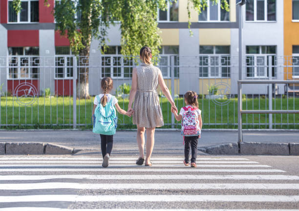 istock Back to school education concept with girl kids, elementary students, carrying backpacks going to class 1164873251
