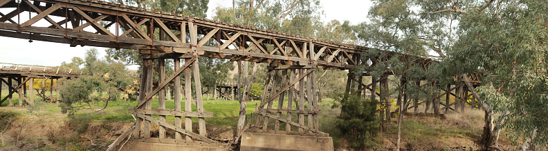 old timber hardwood discontinued railway bridge river crossing in a rural farming town, Victoria, Australia
