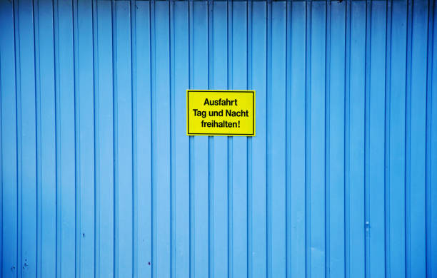 предупреждающий знак: желтый "держать дорогу ясно день и ночь" знак на двери гаража (ausfahrt tag und nacht freihalten! на немецком языке) - ausfahrt стоковые фото и изображения