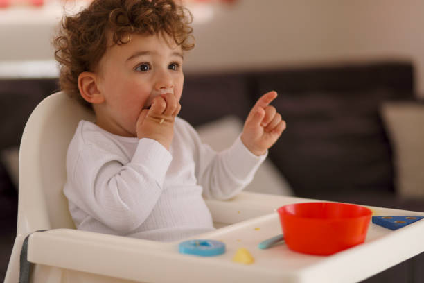 istock Baby boy eating on his own 1164877462