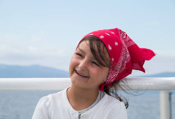 Little girl with a red headscarf Little girl with a red headscarf enjoy traveling by ferry. ferry deck girls stock pictures, royalty-free photos & images