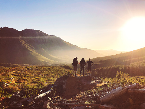 Rearview of Hikers with backpacks enjoying the sunset in the mountains Stellenbosch Cape Town South Africa