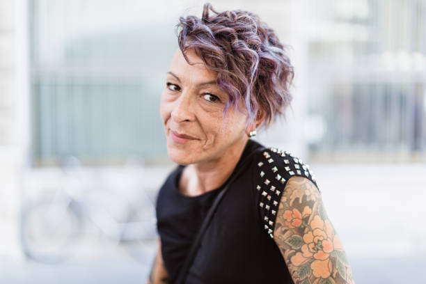 Urban Italian tattooed woman at cafe Urban Italian tattooed woman enjoying coffee break at sidewalk cafe half shaved hairstyle stock pictures, royalty-free photos & images