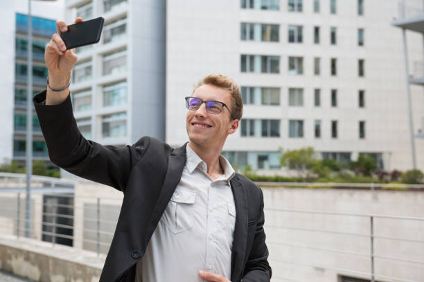 istock Smiling satisfied businessman taking selfie 1164881322