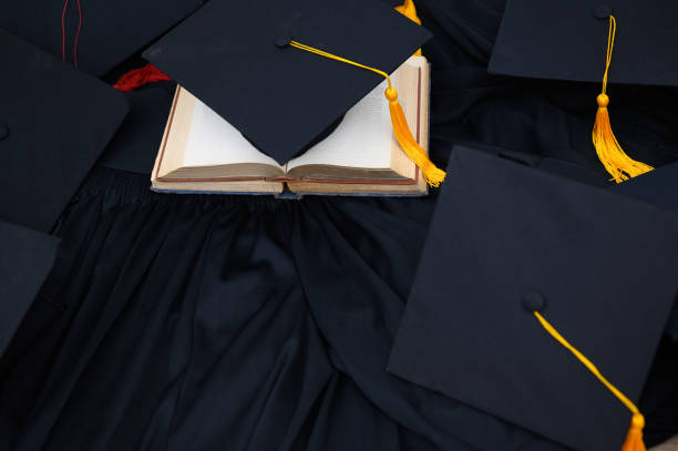 istock Hat of black graduates and books on the table 1164881363