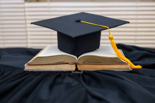 istock Hat of black graduates and books on the table 1164881409