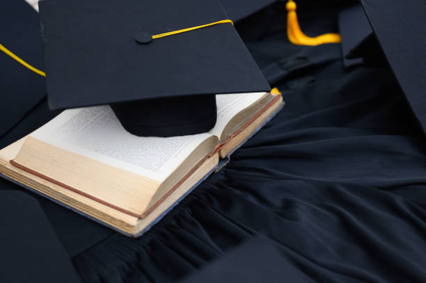 istock Hat of black graduates and books on the table 1164881411