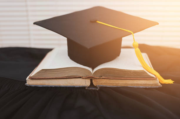 istock Hat of black graduates and books on the table 1164881507