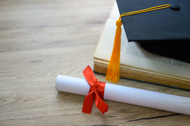 istock Hat of black graduates and books on the table 1164881525