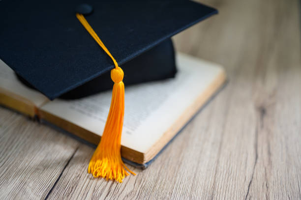 istock Hat of black graduates and books on the table 1164881572
