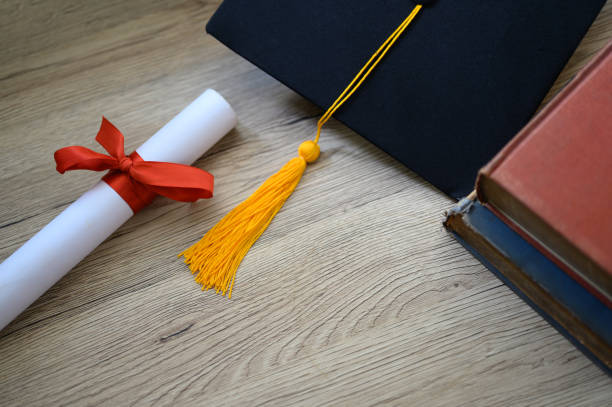 istock Hat of black graduates and books on the table 1164881576
