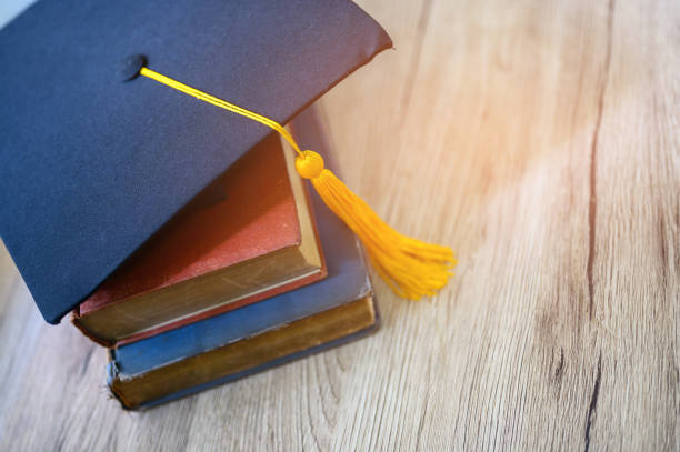 istock Hat of black graduates and books on the table 1164881582