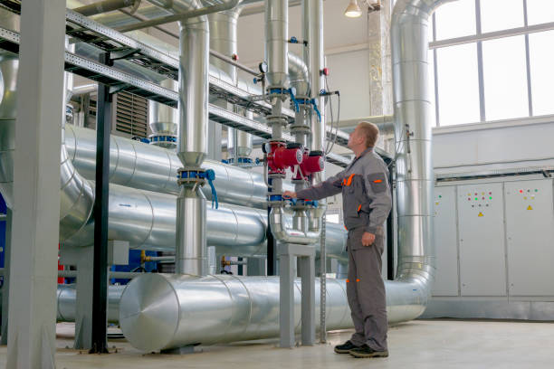 The technician controls the equipment in the boiler room Central heating control system for a large logistics company. piping hot stock pictures, royalty-free photos & images