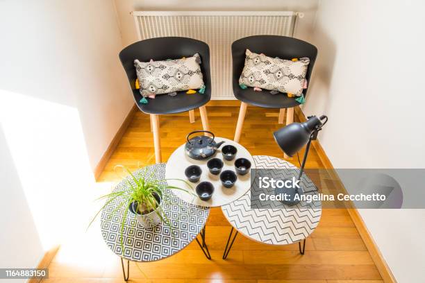 Stylish Interior Decoration Of A Cosy Corner Of A House With Cast Iron Teapot Cups Geometric Tables And Chairs Stock Photo - Download Image Now