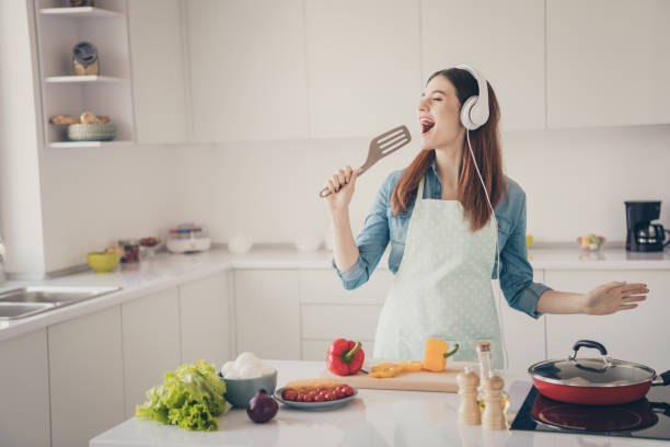 photo of wife begin prepare family dinner singing like rock star with kitchenware utensil overjoyed earflaps playlist - cooking process imagens e fotografias de stock