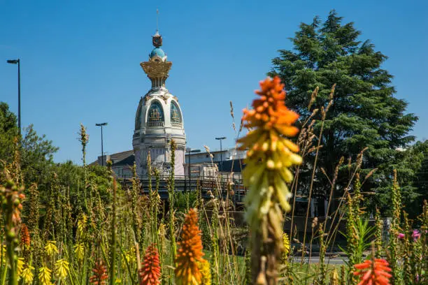 Tour Lu in Nantes on a Sunny Summer Day with Green Vegetation and Orange Common Torch Lilly Flowers