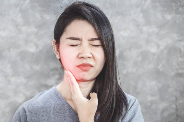 istock Asian woman suffering from toothache problem hand holding and painful 1164888083