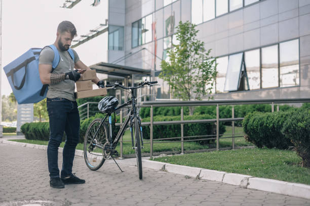 istock Delivery man on a cargo bike, looking for the right direction 1164888300