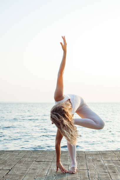 istock woman doing yoga on the sea 1164890129