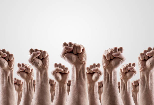 Large group of raised hands showing fists