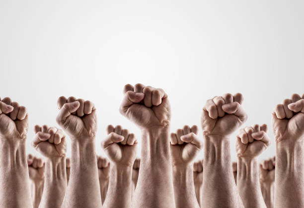 Large group of raised hands showing fists stock photo