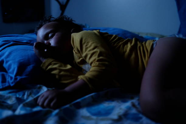 istock Boy sleeping in bed on a summer night 1164892699