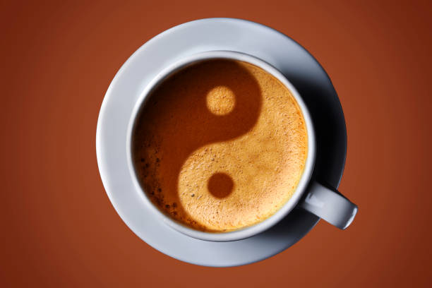 Cup of coffee on black background. Picture of the yin-yang in the coffee crema. top view. coffee in the form of Yin Yang top view stock photo