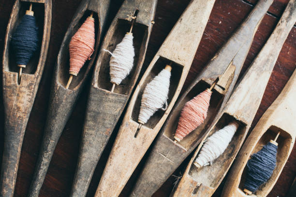 istock Filling carriers of the loom with spool of threads inside 1164894298